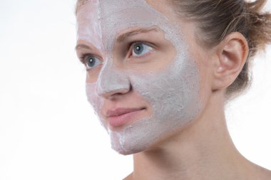 Bodur ve yüzünde krema ile gri kil iki kozmetik maskesi 