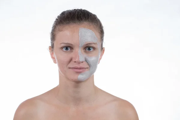 Mascarilla cosmética de arcilla gris con exfoliante en la cara de una joven gir —  Fotos de Stock