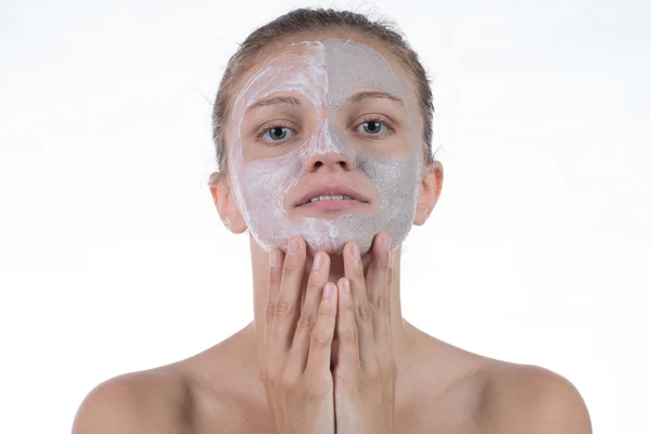 Dos máscara cosmética de arcilla gris con exfoliante y crema en la cara —  Fotos de Stock