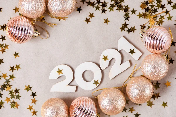 光沢のある金色のクリスマスボール 輝く星がクローズアップされた紙の背景に木製の数字2021 美しい新年カード — ストック写真