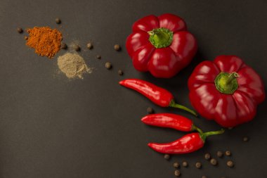 Bezelye siyah bir zemin üzerine bir kaç tatlı ve sıcak olgun kırmızı biber ve baharat biber