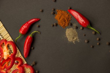 Birkaç olgun güzel kırmızı biber tatlı ve sıcak ve siyah bir zemin üzerine peçeteye biber bezelye