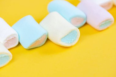 Parlak sarı bir arka planda çok renkli, yumuşak, lokum gibi yakın plan. Şenlik dokusu