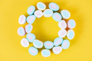 Parlak sarı bir arka planda çok renkli, yumuşak, lokum gibi yakın plan. Şenlik dokusu