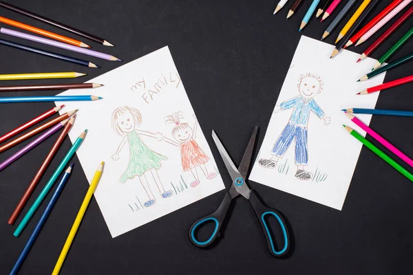 Siyah arka plan üzerine yazılı bir ailenin çizimi. Anne, baba ve bebek el ele tutuşuyorlar. Aile boşanması kavramı. Babanın görüntüsü makasla kesilmiş. İlişki sorunları ve güçlükler 