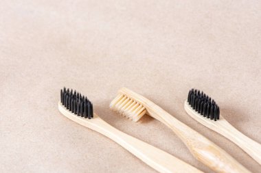 Çevre dostu bambu diş fırçaları kağıt kahverengi arka planda kapanıyor. Sıfır atık