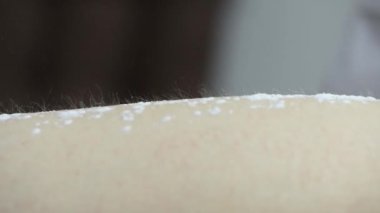 Bir kadının bacaklarındaki kılları ağda yaparak aldırma prosedürünün aşamalarından birine yakın çekim.