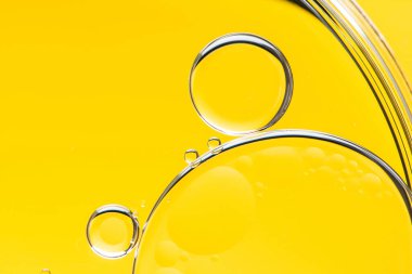 Sarı arka planı olan yağ damlacıklarının güzel ve fantastik bir fotoğrafı. Soyut sanat 