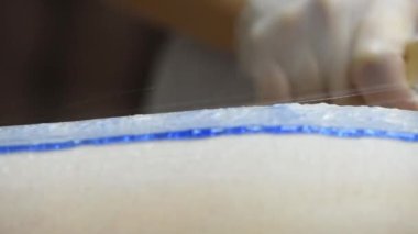 Bir kadının bacaklarındaki kılları ağda yaparak aldırma prosedürünün aşamalarından birine yakın çekim.