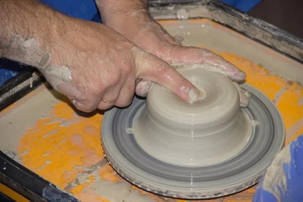 Potter fait sur le pot d'argile de roue de poterie. Les mains d'une potte — Photo