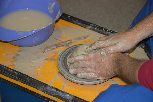 Potter fait sur le pot d'argile de roue de poterie. Les mains d'une potte — Photo