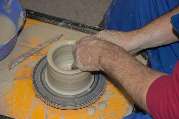 Potter fait sur le pot d'argile de roue de poterie. Les mains d'une potte — Photo