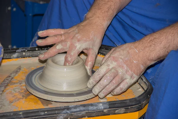 Potter fait sur le pot d'argile de roue de poterie. Les mains d'une potte — Photo