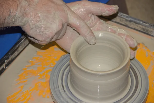 Potter çanak çömlek çarkı kil sürahi üzerinde yapar. Elinde bir potte — Stok fotoğraf