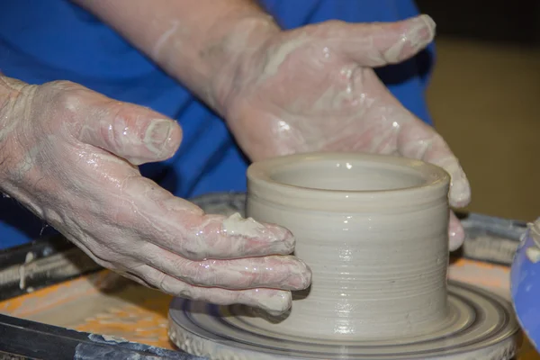 Potter fait sur le pot d'argile de roue de poterie. Les mains d'une potte — Photo