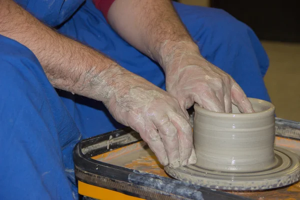 Potter fait sur le pot d'argile de roue de poterie. Les mains d'une potte — Photo