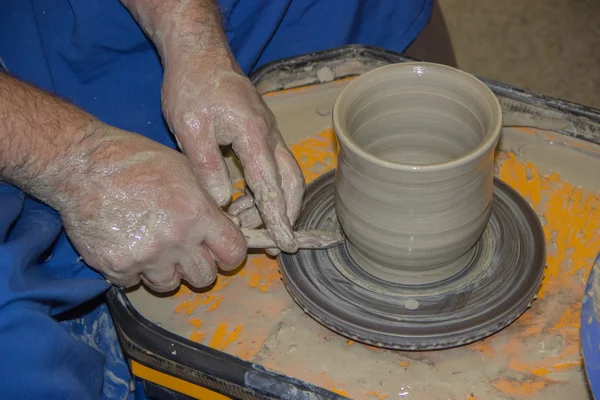 Potter çanak çömlek çarkı kil sürahi üzerinde yapar. Elinde bir potte — Stok fotoğraf