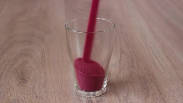 Colored sand is poured into the glass and seashells placed on top — Stock Video