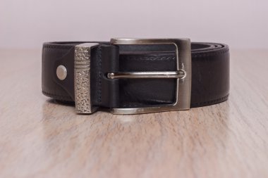 ahşap tahta üzerinde bir toka ile deri kemer