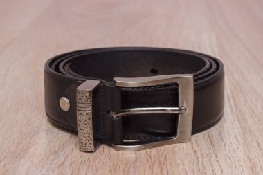 ahşap tahta üzerinde bir toka ile deri kemer