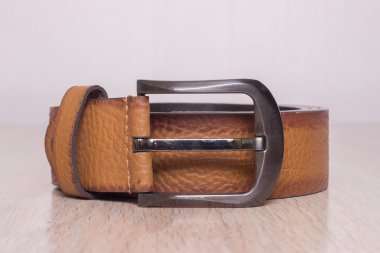 ahşap tahta üzerinde bir toka ile deri kemer