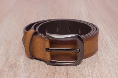 ahşap tahta üzerinde bir toka ile deri kemer