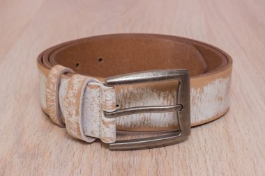 ahşap tahta üzerinde bir toka ile deri kemer