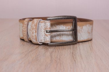 ahşap tahta üzerinde bir toka ile deri kemer