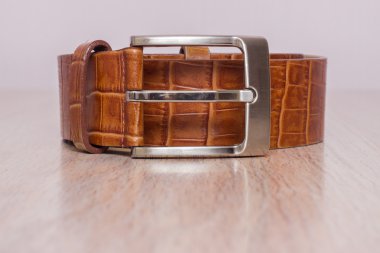 ahşap tahta üzerinde bir toka ile deri kemer