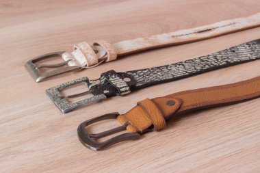 ahşap tahta üzerinde bir toka ile deri kemer