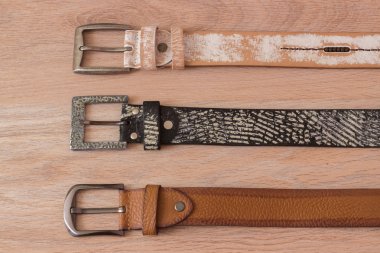 ahşap tahta üzerinde bir toka ile deri kemer