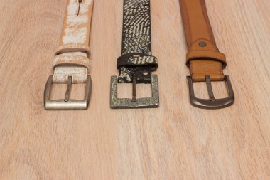 ahşap tahta üzerinde bir toka ile deri kemer