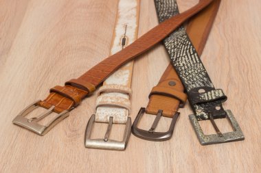 ahşap tahta üzerinde bir toka ile deri kemer