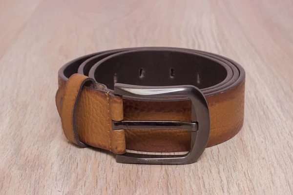 ahşap tahta üzerinde bir toka ile deri kemer