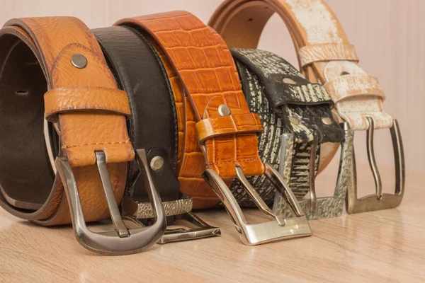 Leather belt with a buckle on a wooden board — Stock Photo, Image