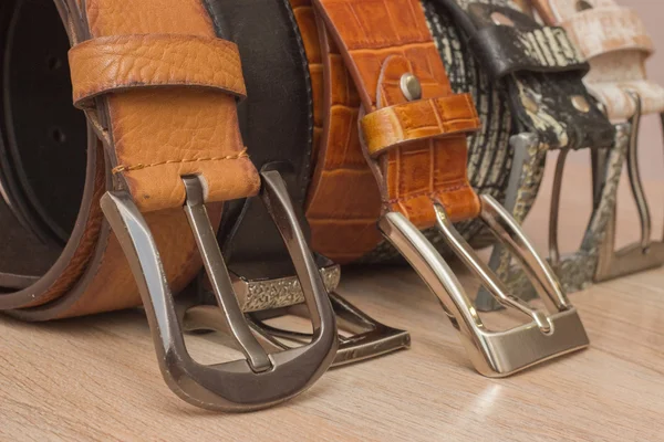 Leather belt with a buckle on a wooden board — Stock Photo, Image