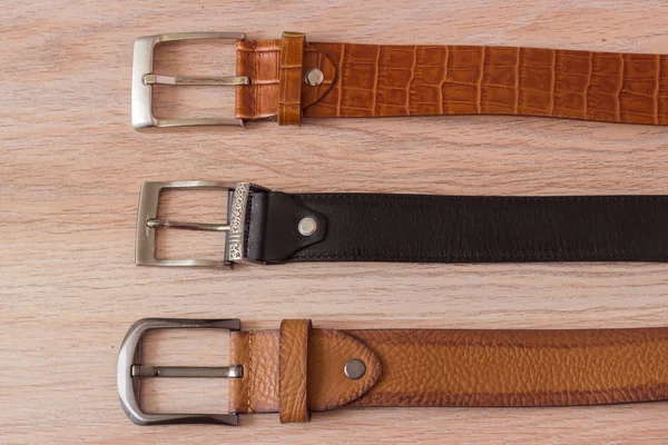 ahşap tahta üzerinde bir toka ile deri kemer