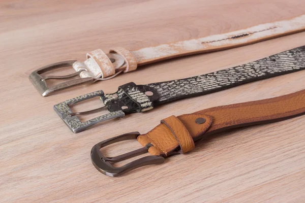 ahşap tahta üzerinde bir toka ile deri kemer