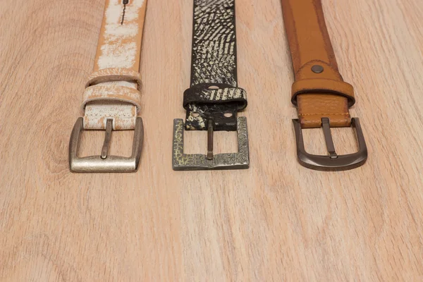 ahşap tahta üzerinde bir toka ile deri kemer