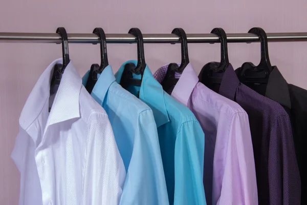 Camisas masculinas coloridas que penduram em cabides — Fotografia de Stock