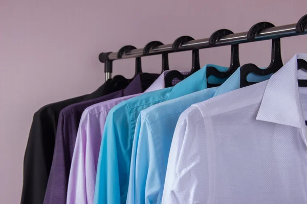 Camisas masculinas coloridas que penduram em cabides — Fotografia de Stock