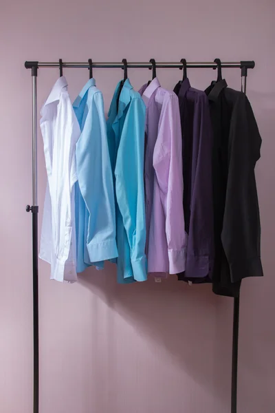 Camisas masculinas coloridas que penduram em cabides — Fotografia de Stock