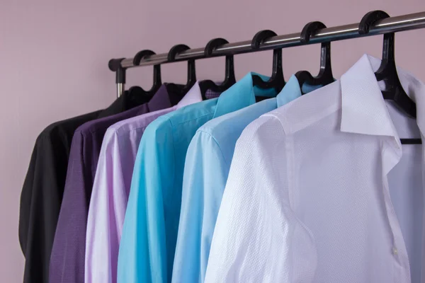 Camisas masculinas coloridas que penduram em cabides — Fotografia de Stock