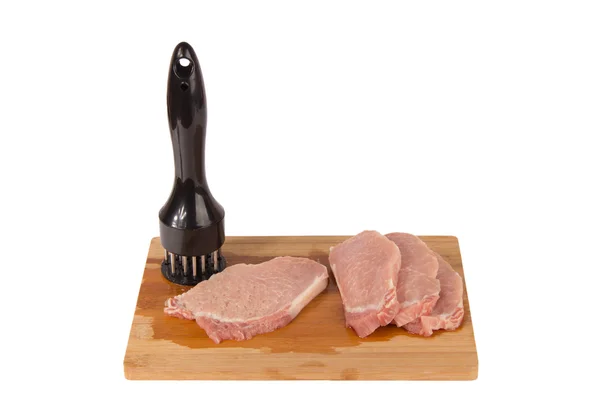 Bater a carne em uma tábua de madeira em um fundo branco — Fotografia de Stock