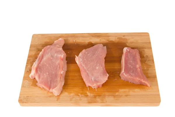 Peça crua de carne em uma tábua de madeira em um fundo branco — Fotografia de Stock