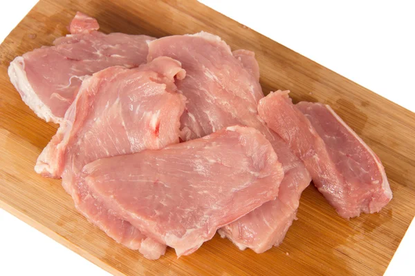 Peça crua de carne em uma tábua de madeira em um fundo branco — Fotografia de Stock