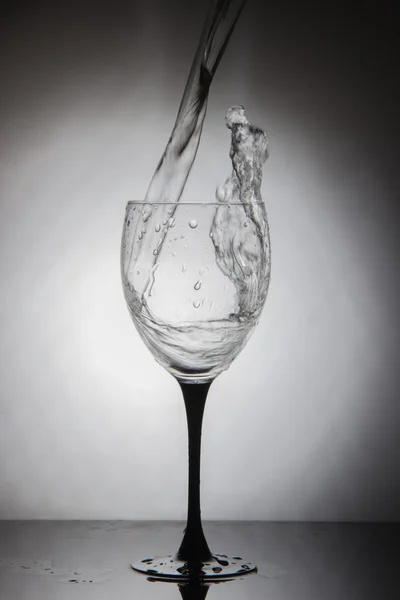 Bicchiere con spruzzi di acqua potabile pulita — Foto Stock