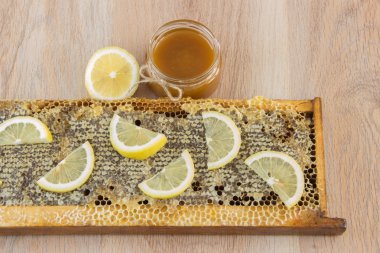 Altın bal tarak bir kavanoz ve sarı dilimlenmiş limon