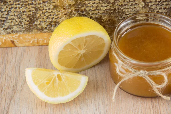 황금 벌 꿀 병에 노란색 슬라이스 레몬 빗 — 스톡 사진