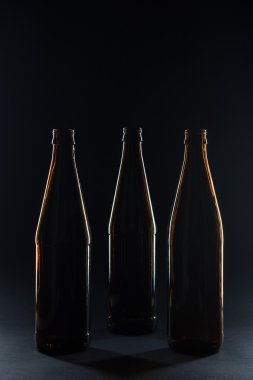 Siluetleri cam şişe bira siyah bir arka plan için kahverengi